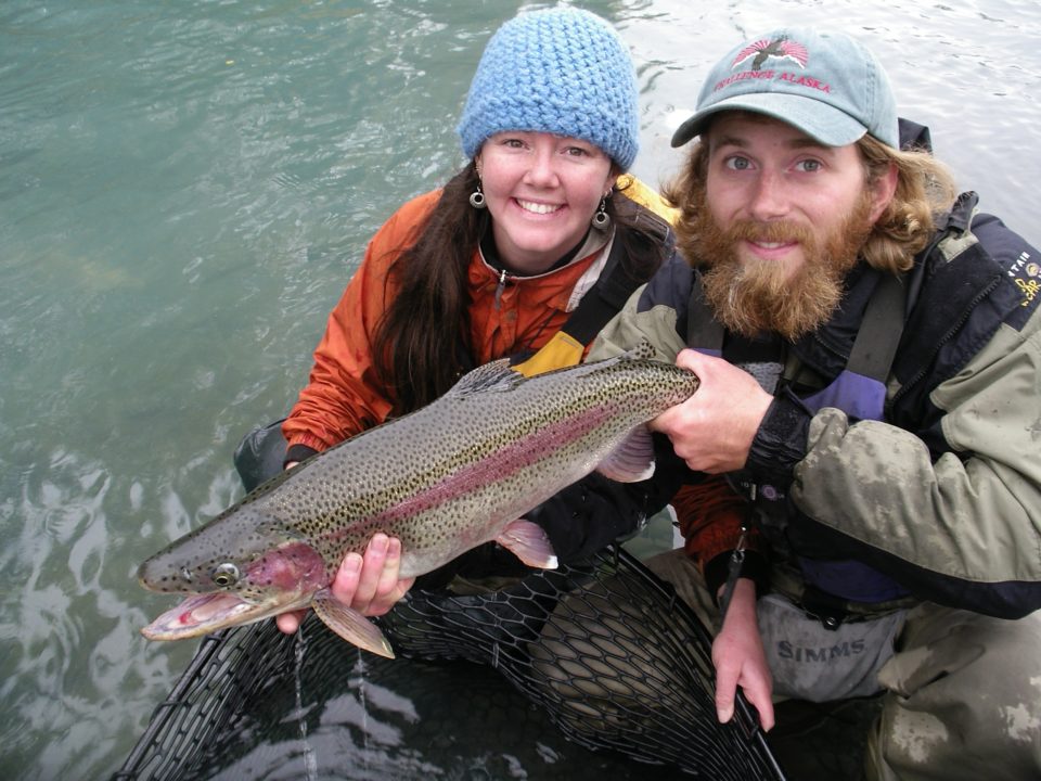 smiling couple holding rainbow trout